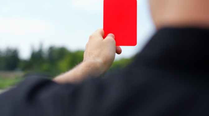 over the shoulder view of a referee showing the red card