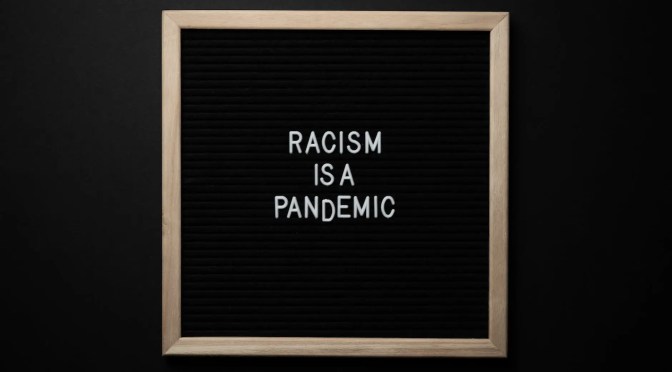phrase racism is pandemic on signboard
